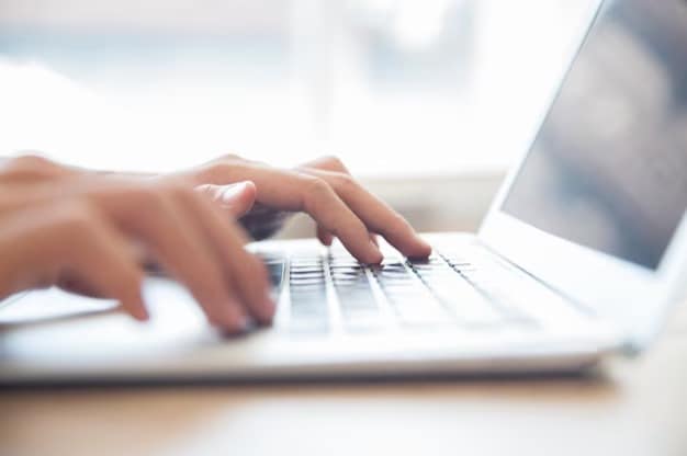hands typing on a laptop